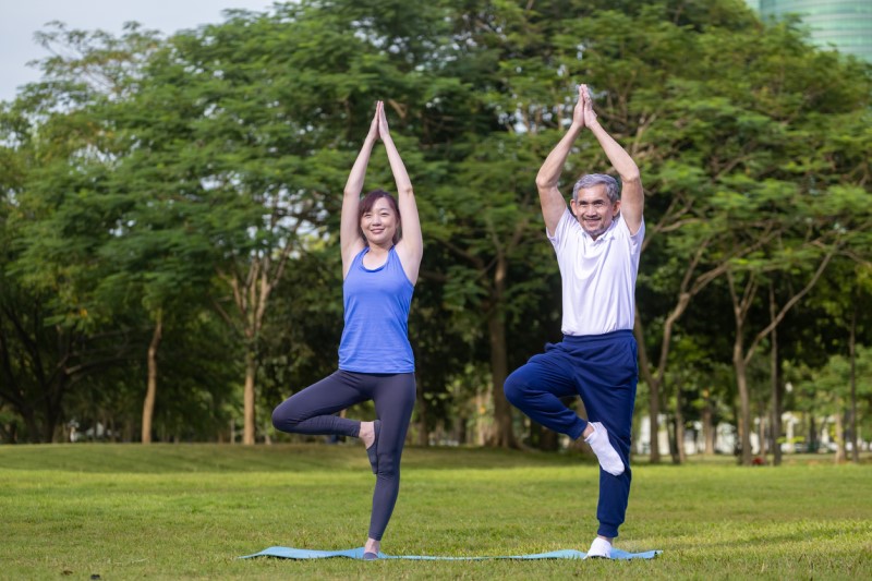 One woman and one man doing exercise in the park.